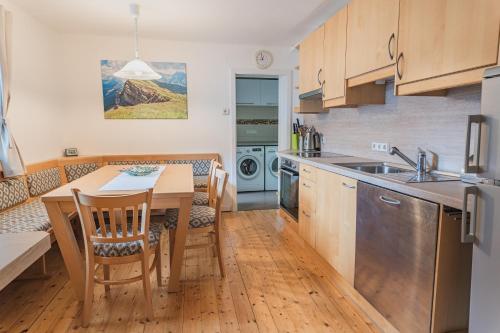 安纳贝格-伦格茨freeride-living的带木桌的厨房和餐厅