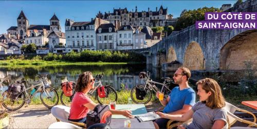 a group of people sitting at a table near a river at Manoir 1838 à - 3 km du Zoo de Beauval & proche des châteaux in Saint-Aignan