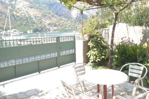 a patio with tables and chairs and a view of the water at Garden Apartment- near sea 2 in Dobrota