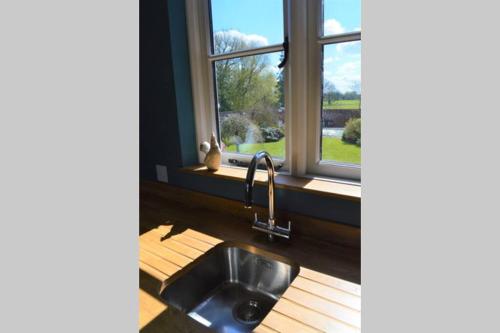 a kitchen with a sink and a window at Cockloft Romantic Countryside Hideaway in Bishops Cannings