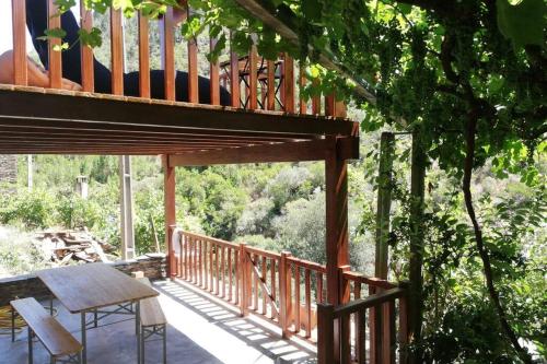 a wooden deck with a table and a bench on it at Casa do Avô Alváro - Refugio do Rei in Casal do Rei