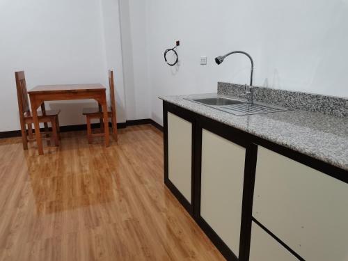 uma cozinha com lavatório e piso em madeira em AFS Suites Barra, Opol em Cagayan de Oro