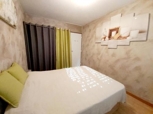 a bedroom with a white bed and a yellow curtain at :) Spacieux T4 AÉROPORT, ensoleillé, déco soignée in Blagnac