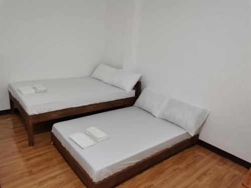 two twin beds in a room with wooden floors at AFS Suites Barra, Opol in Cagayan de Oro