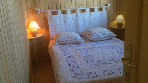 a bedroom with a white bed with two pillows at L'Aubépine in Mollans-sur-Ouvèze