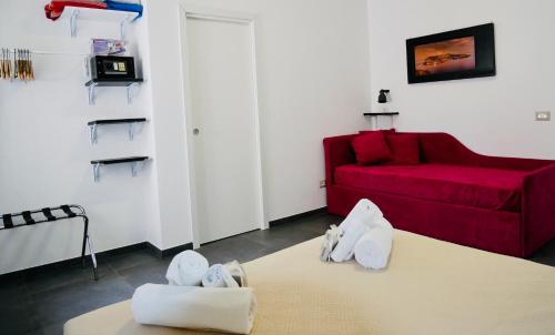 a living room with a red couch and white towels at "Sweet Life" Casa Vacanze in Lipari