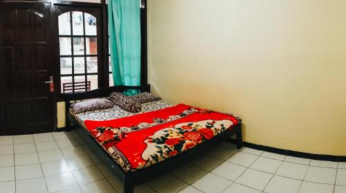 a small bed in a room with a window at Hotel Gunung Mas Syariah in Dieng