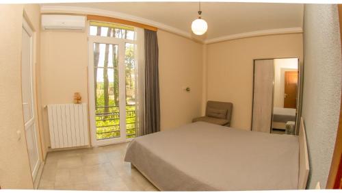 a bedroom with a bed and a window and a chair at Shekvetili Big Wonder in Shekhvetili