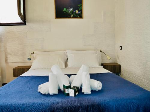 a bed with white towels on a blue blanket at "Sweet Life" Casa Vacanze in Lipari