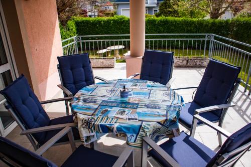 a table and four chairs on a patio at Nefelejcs Apartmanház in Gyenesdiás