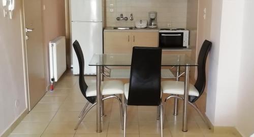 a kitchen with a table with chairs and a refrigerator at Nefeli Studios in Loutra Edipsou