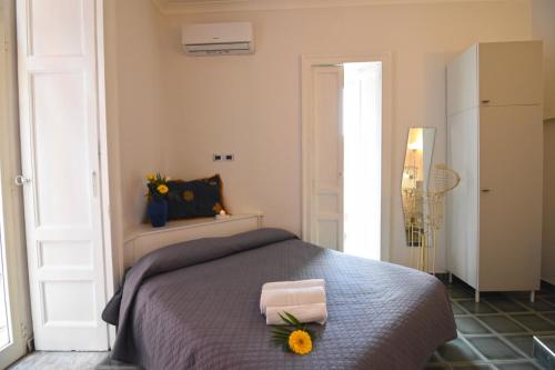 ナポリにあるNanà Bed and Breakfastの花が飾られたベッドのある寝室