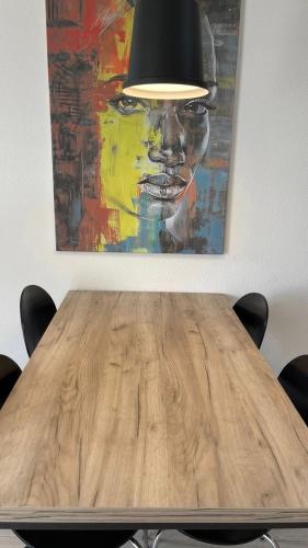 a wooden table in a room with a painting at Apartments Mrdak in Bar