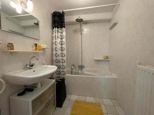 uma casa de banho branca com um lavatório e uma banheira em Hunting Lodge 104 em Lunteren