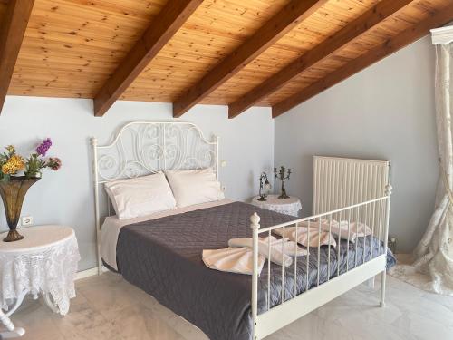 a bedroom with a white bed and a wooden ceiling at Thèros Mansion 5BR Mansion Sky Villa 360 Views, Infinity Pool & Jacuzzi Spa in Planos