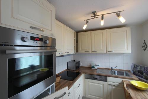a kitchen with white cabinets and a stove top oven at Samlandhaus in Timmendorfer Strand