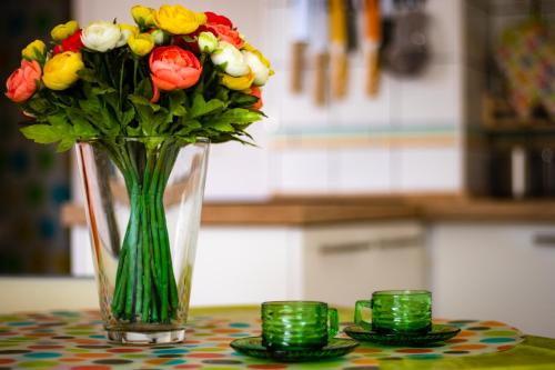 a vase with a bouquet of flowers on a table at Nefelejcs Apartmanház in Gyenesdiás