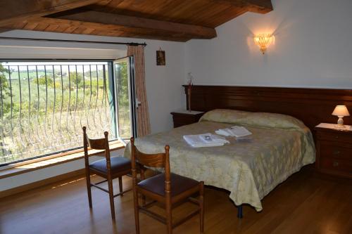 a bedroom with a bed with two chairs and a window at Villa San Giacomo in Scerni