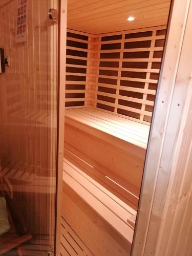 a wooden sauna with a wooden floor and a glass door at Vila Salamander in Štanjel