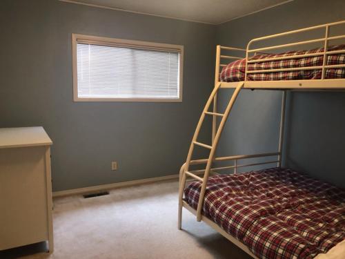een slaapkamer met 2 stapelbedden en een raam bij Retro West Near Indian Creek Golf Course - 30 day minimum home in Hood River