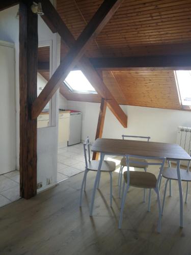une salle à manger avec une table et des chaises en bois dans l'établissement En mansarde sur le port, à Les Sables-dʼOlonne