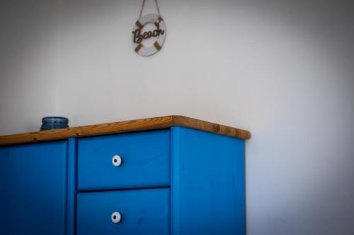 a blue dresser against a white wall at Nefelejcs Apartmanház in Gyenesdiás
