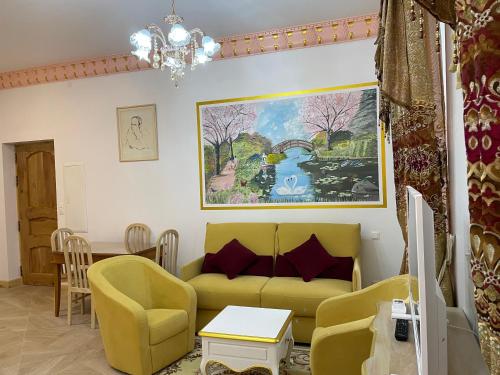 a living room with a yellow couch and chairs at Studio Romantique Maison de L'église du Couvent in Narbonne