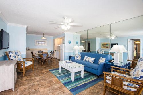 a living room with a blue couch and a table at Jupiter Reef Club Resort in Jupiter