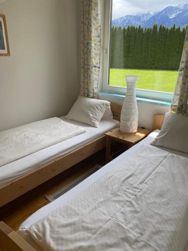 2 Betten in einem Zimmer mit Fenster in der Unterkunft V Gemütliches Gartenhaus in Smihel nad Pliberkom