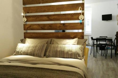 Un dormitorio con una cama con cabecero de madera. en Appartamento VIA COLOMBO 99, en Riomaggiore