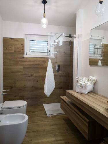 a bathroom with a toilet and a sink and a mirror at Villa Maria in Dorgali
