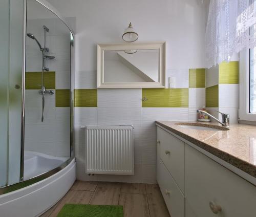 a bathroom with a shower and a sink and a tub at Rodzinny Apartament na Kaszubach in Brusy