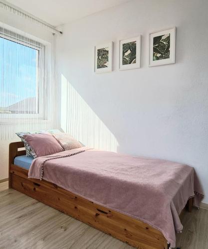 a bedroom with a bed with a purple blanket and a window at Rodzinny Apartament na Kaszubach in Brusy