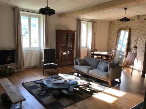 uma sala de estar com um sofá e uma mesa em Golf Val de Sorne Vernantois Maison vigneronne em Vernantois
