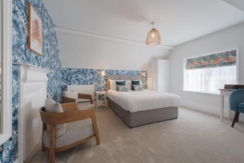 een slaapkamer met een bed, een bureau en een stoel bij Florence Suite Boutique Hotel and Restaurant in Portsmouth