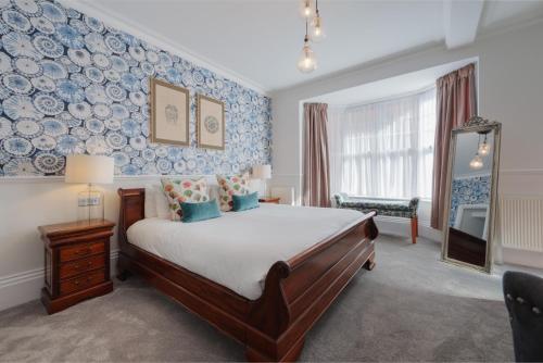 a bedroom with a bed with blue and white wallpaper at Florence Suite Boutique Hotel and Restaurant in Portsmouth