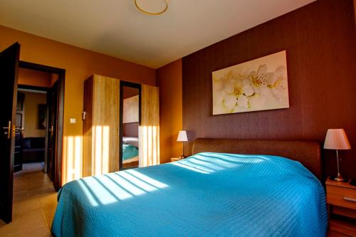 a bedroom with a bed with a blue blanket at Panorama Apartman in Zamárdi