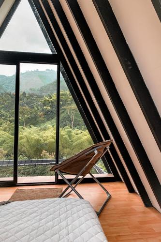 a bedroom with a bed and a large window at Intrepido Glamping in Chinchiná