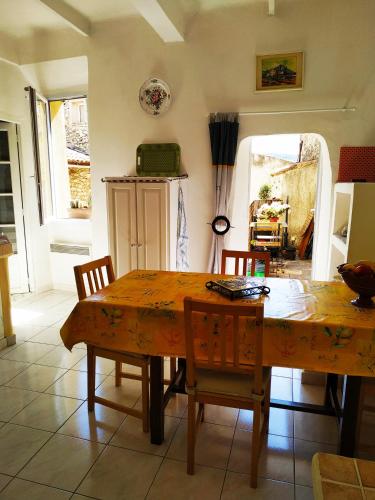 a dining room table and chairs in a room at GITE AU COEUR DES GORGES DU VERDON in Quinson