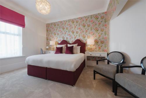 a bedroom with a large bed and a chair at Florence House Boutique Hotel and Restaurant in Portsmouth