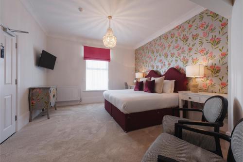 a hotel room with a bed and a desk and a window at Florence House Boutique Hotel and Restaurant in Portsmouth
