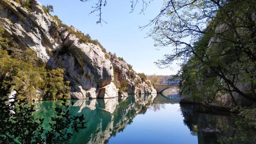 a view of a river with a bridge in the background at GITE AU COEUR DES GORGES DU VERDON in Quinson