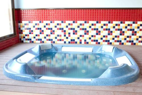 a blue bath tub in front of a tile wall at CHALET CERCA DE NOJA CON ACCESO A SPA in Beranga