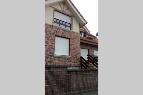 a brick house with three windows on the side of it at CHALET CERCA DE NOJA CON ACCESO A SPA in Beranga