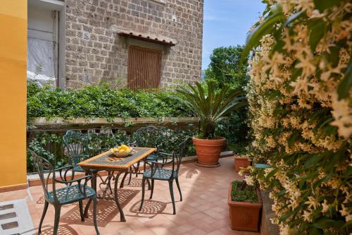 a patio with a table and chairs and plants at Sine Tempore in Sorrento