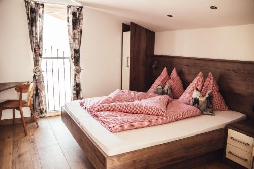 a bedroom with a bed with pink pillows at Appartement Pointschneiderhof in Maishofen