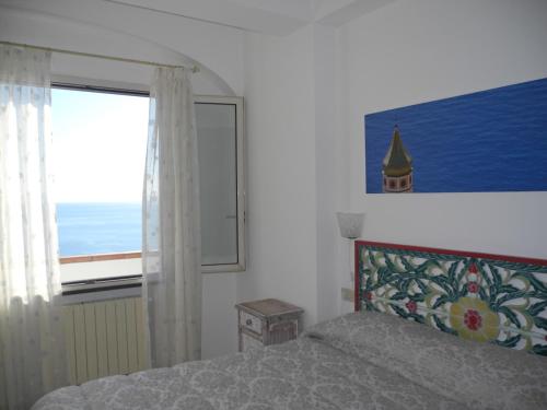 a bedroom with a bed and a window at Moonlight house in Praiano