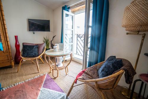 Una sala de estar con mesa y sillas y un balcón. en La Belle Amarre-Bed and Breakfast-Maison d'Hôtes, en La Rochelle