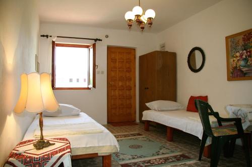 a room with two beds and a lamp and a window at Apartments Morski Vuk in Tivat