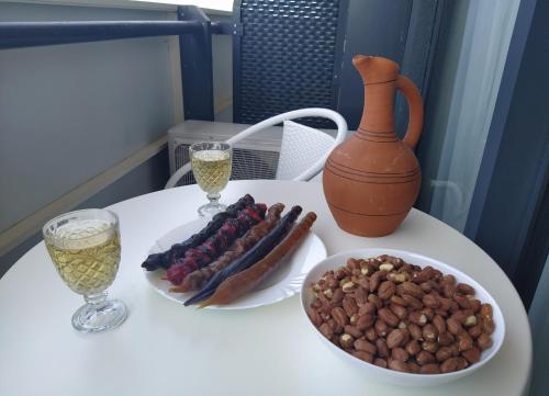 a table with two glasses of wine and a bowl of nuts at Orbi City Superhost in Batumi